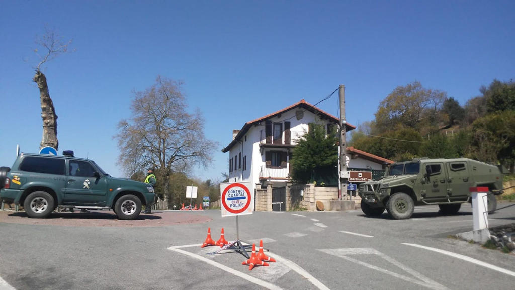 Un equipo militar con VAMTAC 4x4 (derecha) controla el acceso a una población junto a una patrulla de la Guardia Civil.