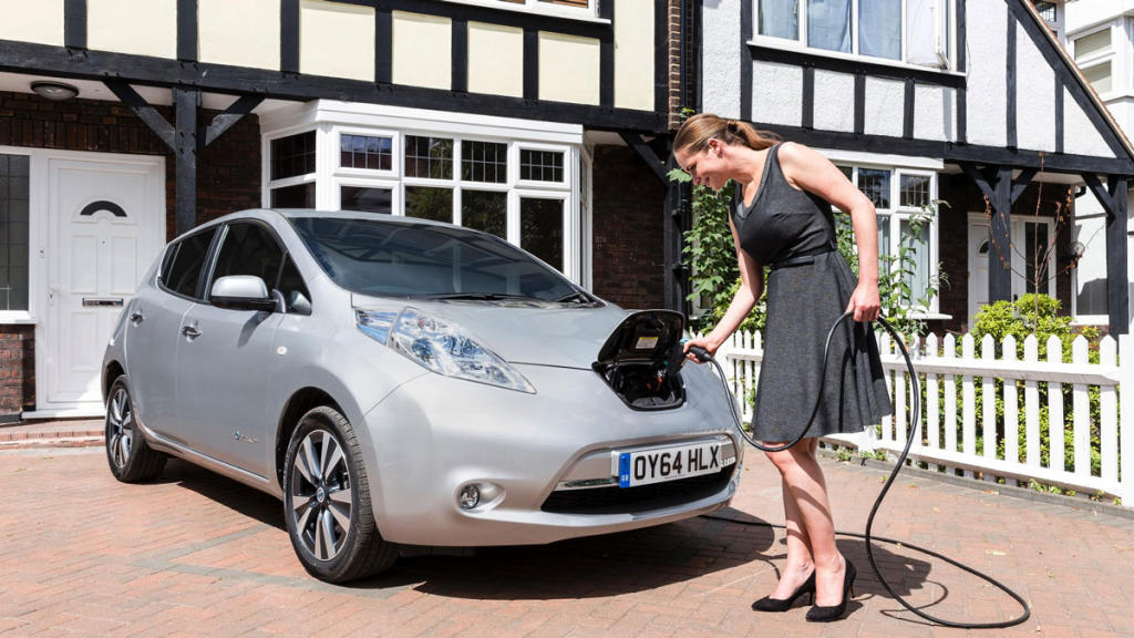 Mujer enchufando Nissan Leaf de primera generación