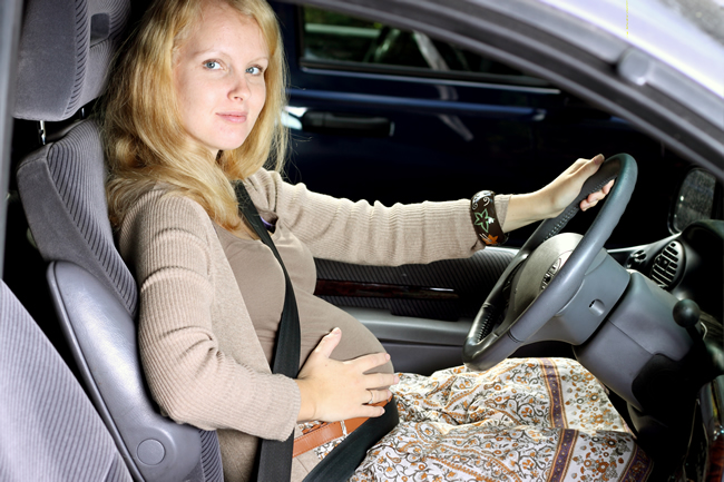 La mujer embarazada en el coche usando el cinturón de seguridad, vista  lateral Fotografía de stock - Alamy