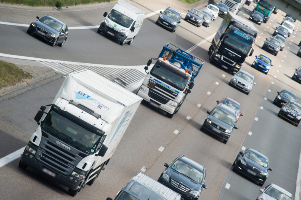 Busses, commercial vehicles, vans and lorries driving on a motorway