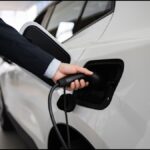 Business,Professional,Displaying,Electric,Car,At,Vehicle,Dealership.,Hand,Connecting