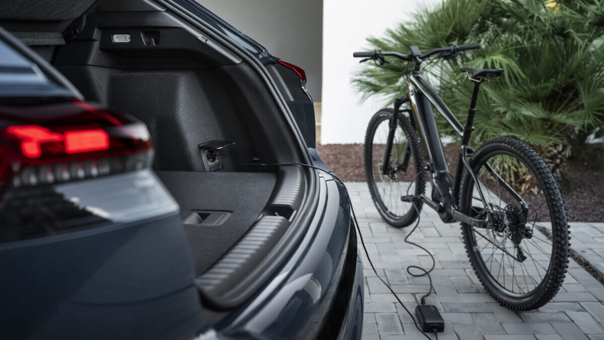 El Audi Q4 e-tron carga una bicicleta eléctrica con la función V2L desde el maletero