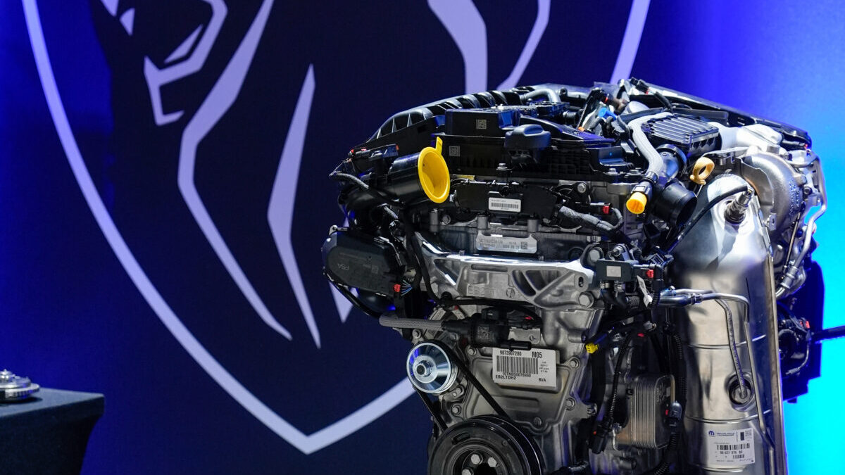 El motor Turbo 100 sobre su peana, con el logotipo de Peugeot al fondo