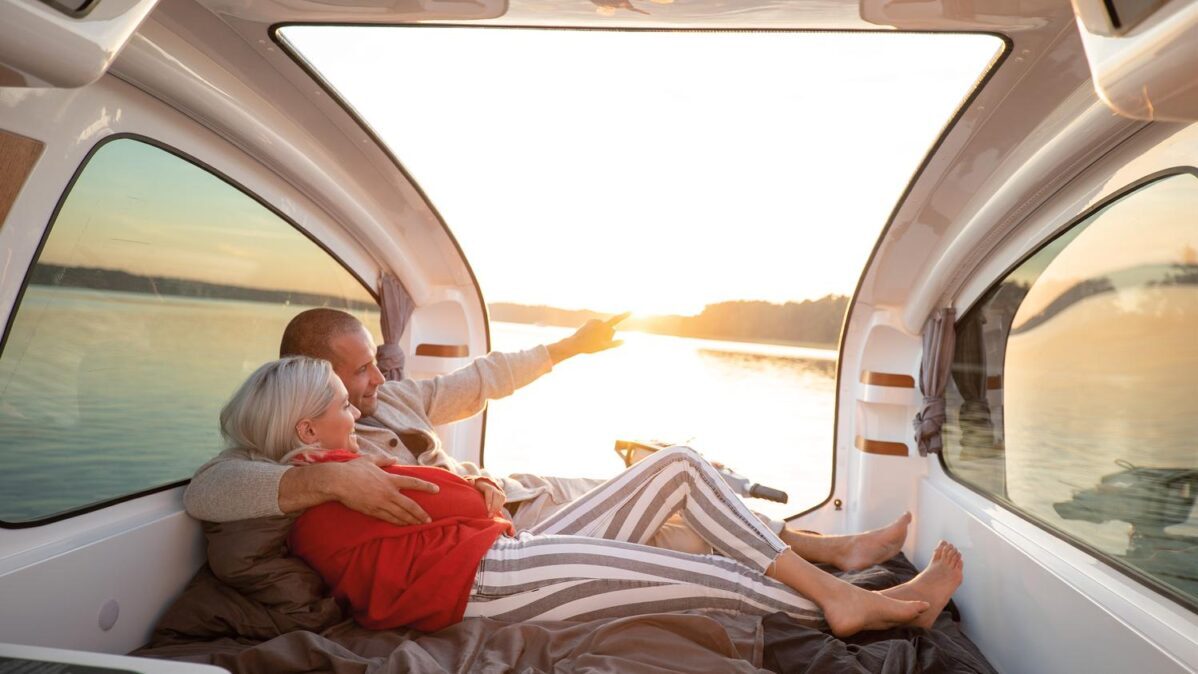 Interior del Sealander con la cama montada y la escotilla abierta al atardecer