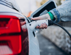 Cargar el coche eléctrico en casa: cuánto cuesta instalar un cargador y qué potencia necesitas de verdad Woman charging her electric car with charging pistol